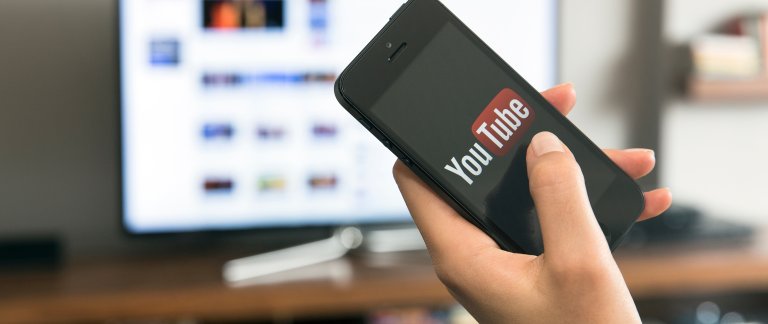 telefon med youtube og tv i bakgrunn foto istock