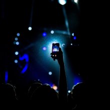 Illustrasjonsbilde. Mann som filmer konsert med mobilen