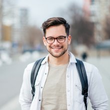 Portrettbilde av ung mann med briller og ryggsekk